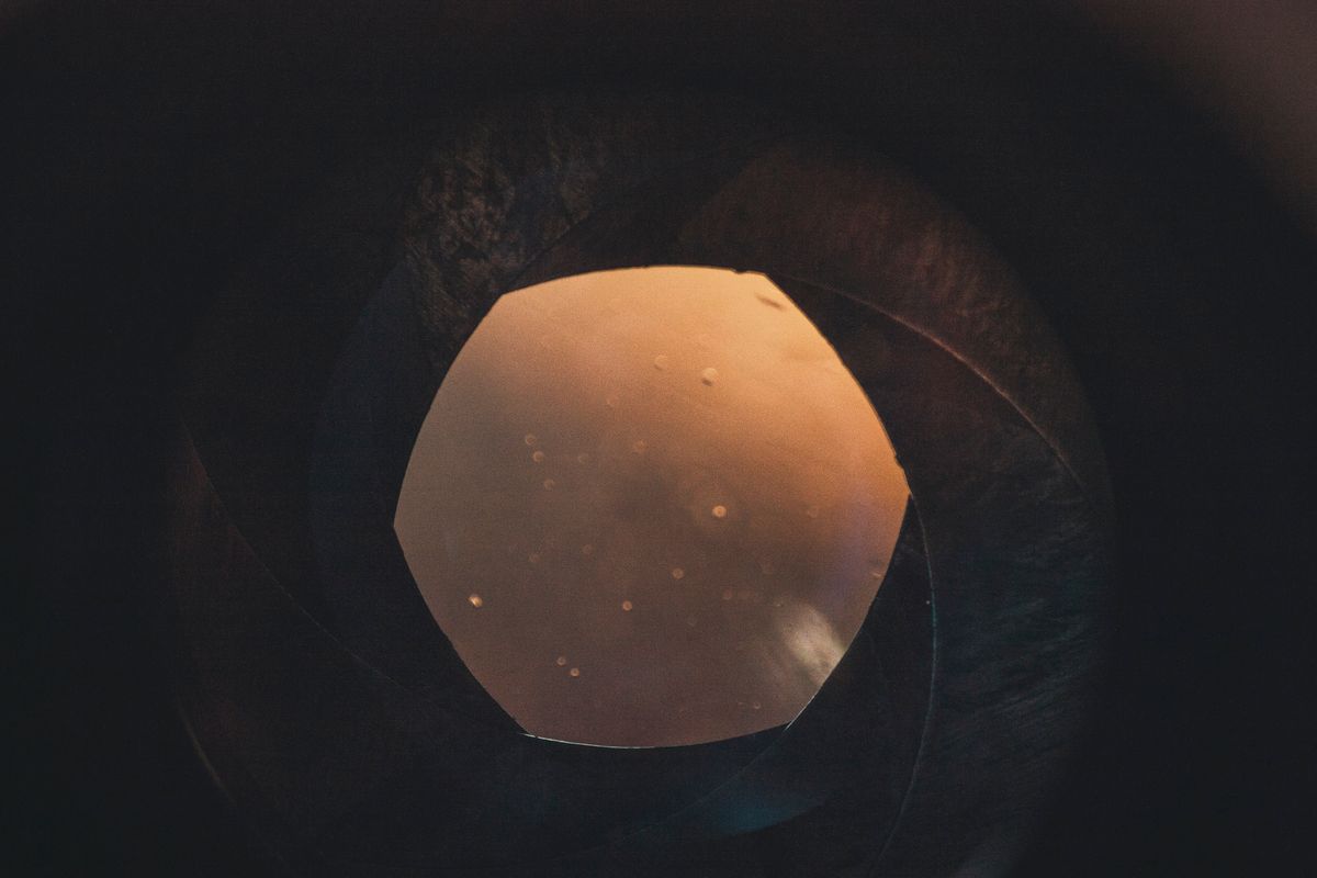 Close-up of a professional camera lens showing the glass elements and mechanical structure