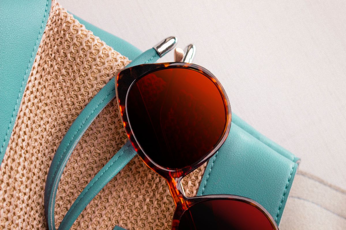 Polarised sunglasses on a straw bag representing outdoor glare reduction and polarisation in everyday life