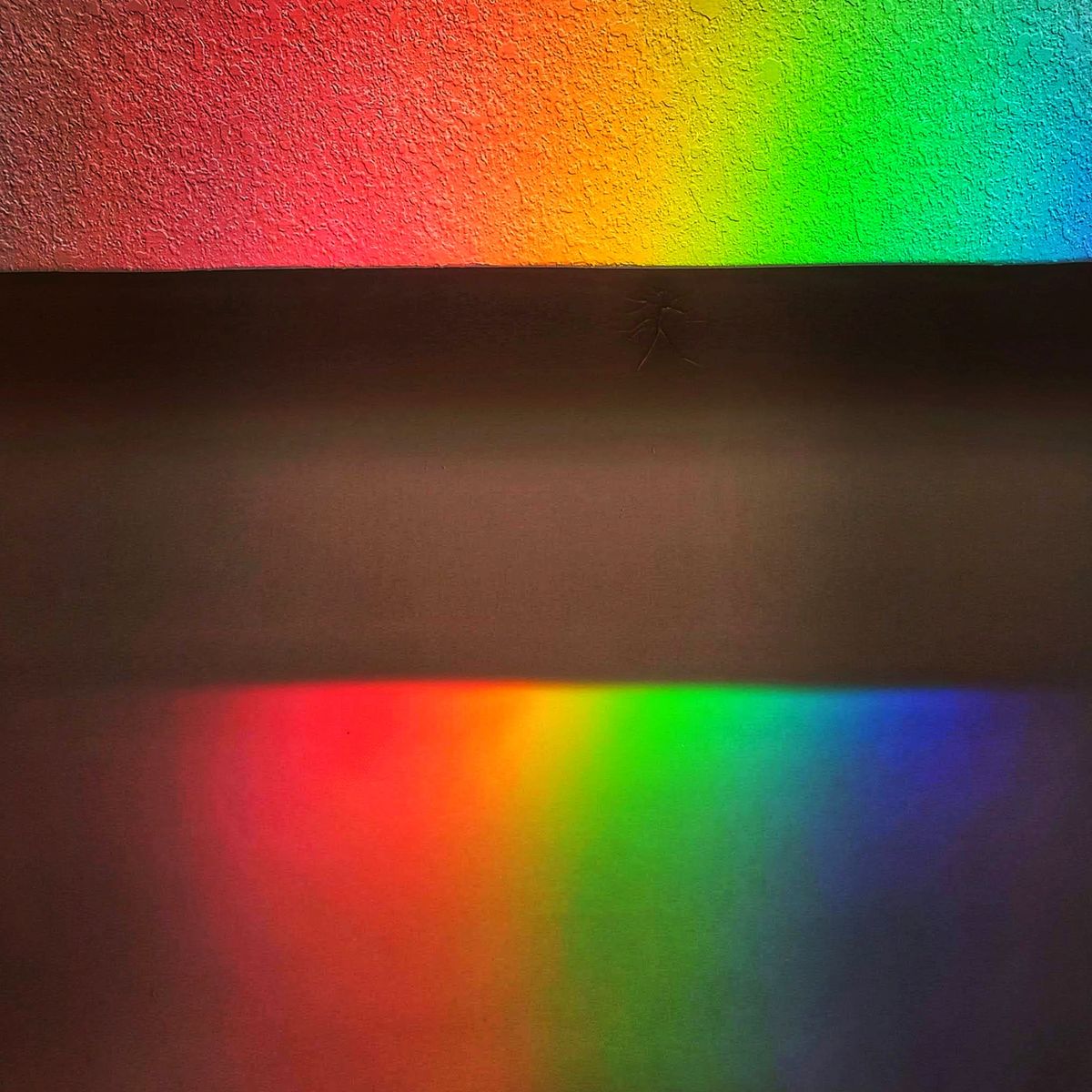 Vibrant rainbow colors on a textured wall surface, illustrating the colors of the rainbow in order from red to violet