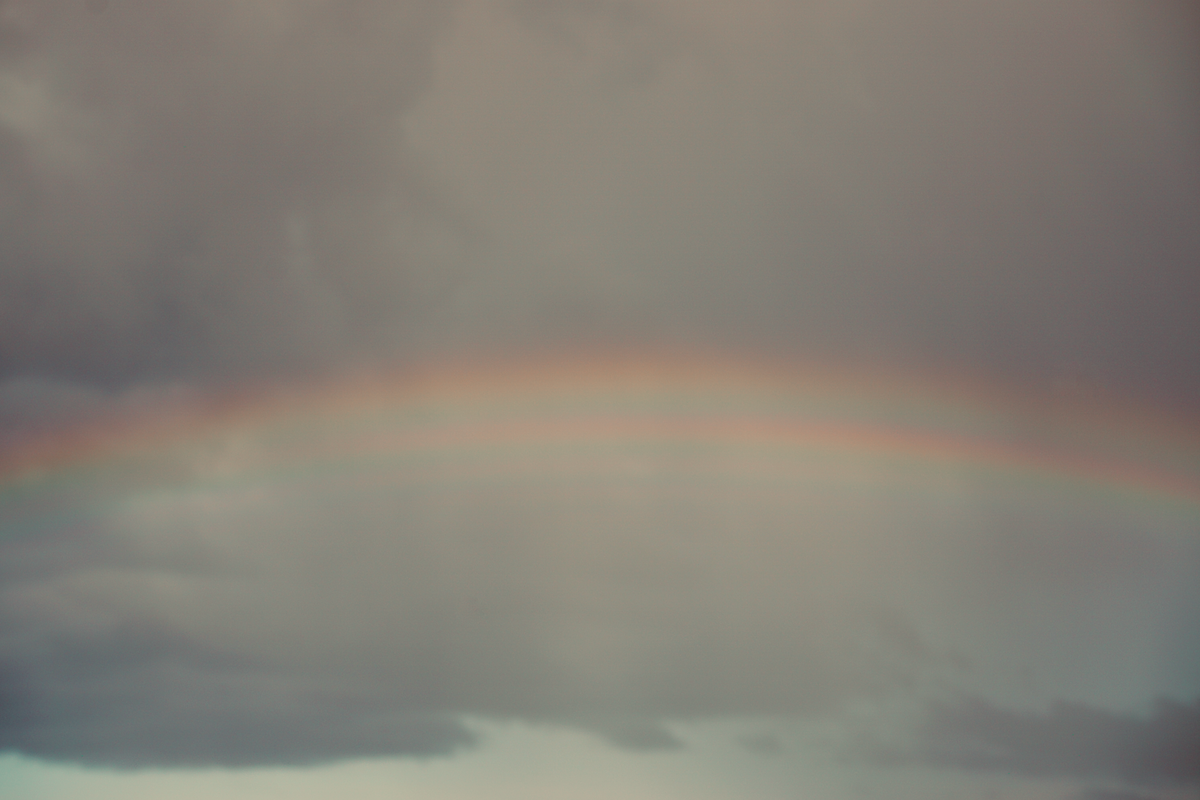 types of rainbows a tranquil rainbow arcs across a cloudy gray sky after a storm reflecting nature beauty