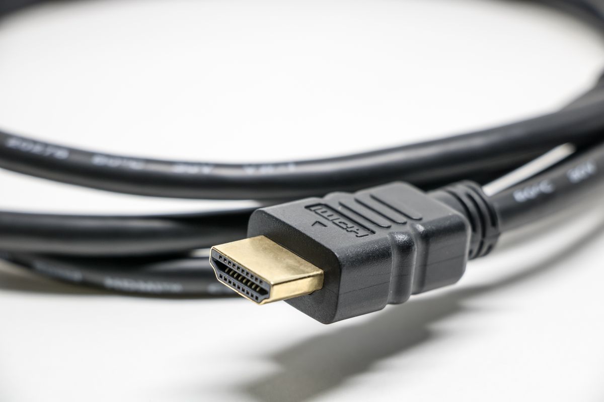 Optical audio cable vs HDMI: a black HDMI cable with gold connectors compared with an optical audio cable TOSLINK connection
