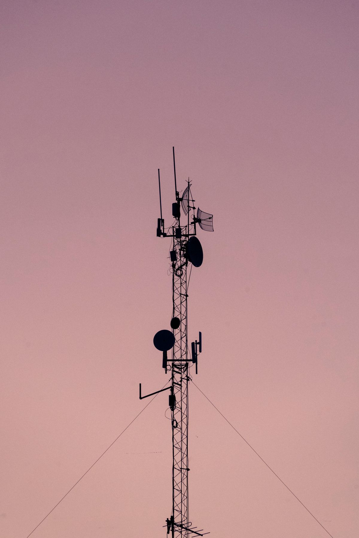 Telecommunication tower against a sunset sky representing fibre optic infrastructure and wide-area network bandwidth