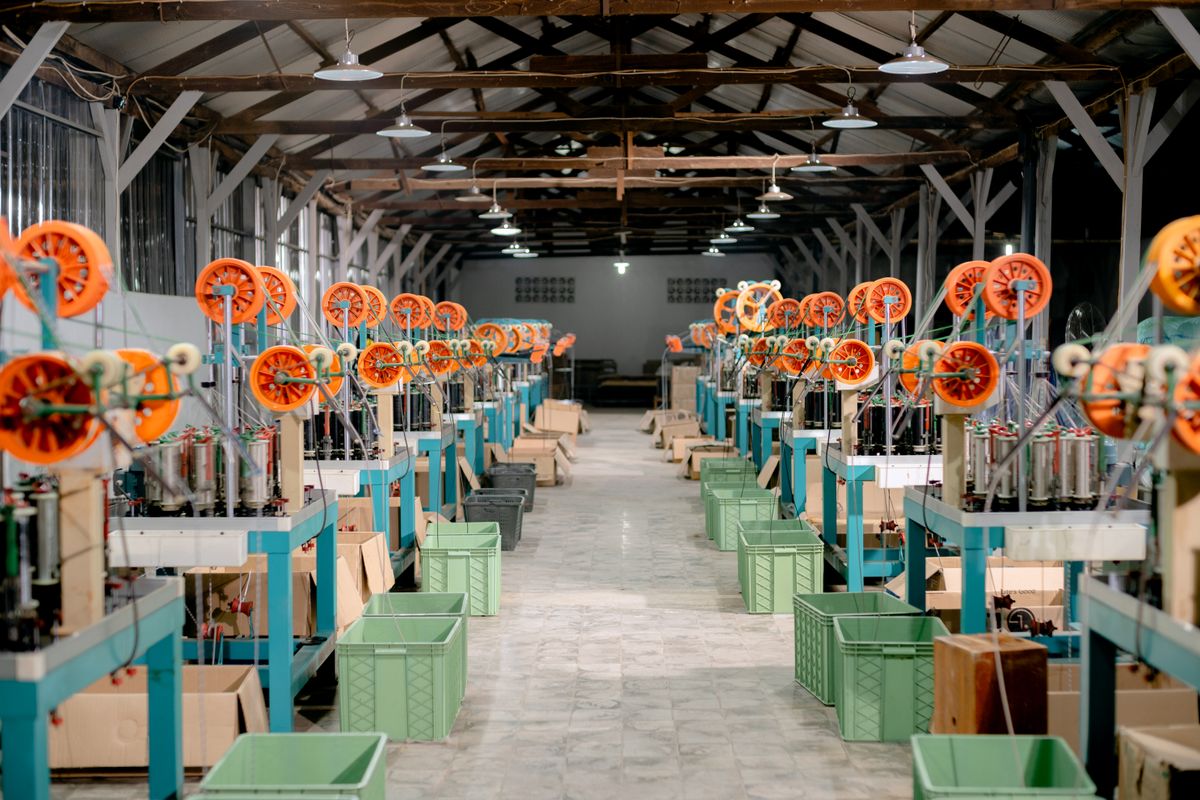 How is fiber optic cable made: an industrial manufacturing hall where fiber optic preforms are created before drawing