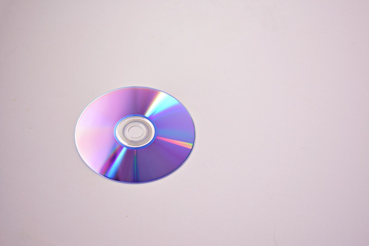 Colourful CD reflecting rainbow diffraction pattern from its microscopic grooves, a clear everyday example of how light bends during diffraction
