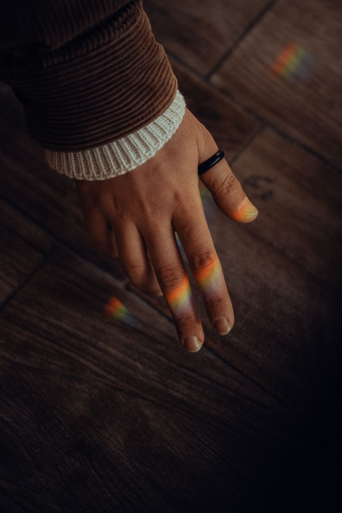 A vibrant rainbow spectrum of colours from a diffraction grating or prism creating an abstract pattern on a dark background