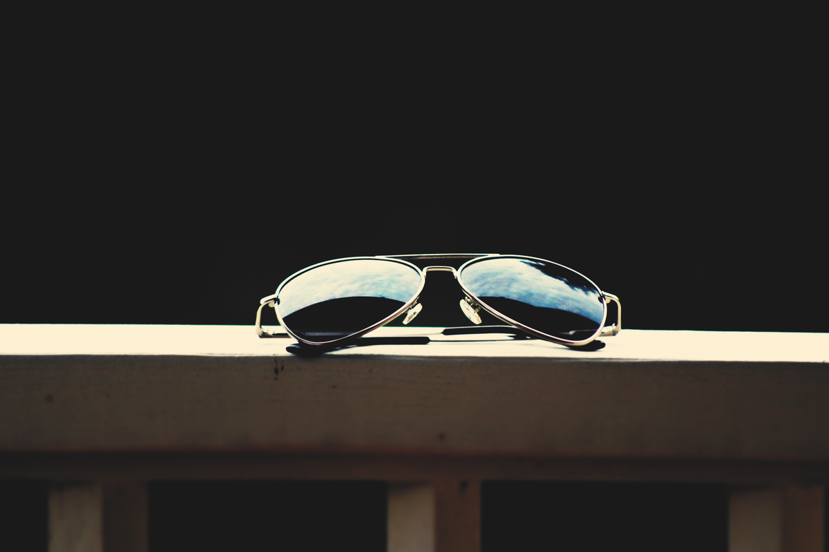 What is polarized light: aviator sunglasses reflecting the sky, their lenses filtering one orientation of light