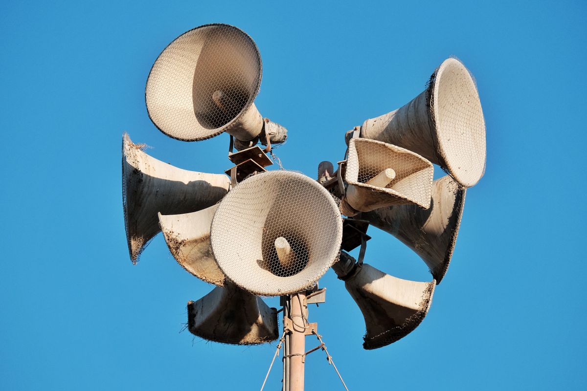 Close-up of multiple aged megaphones on a pole, showing how sound waves can be directed and reflected