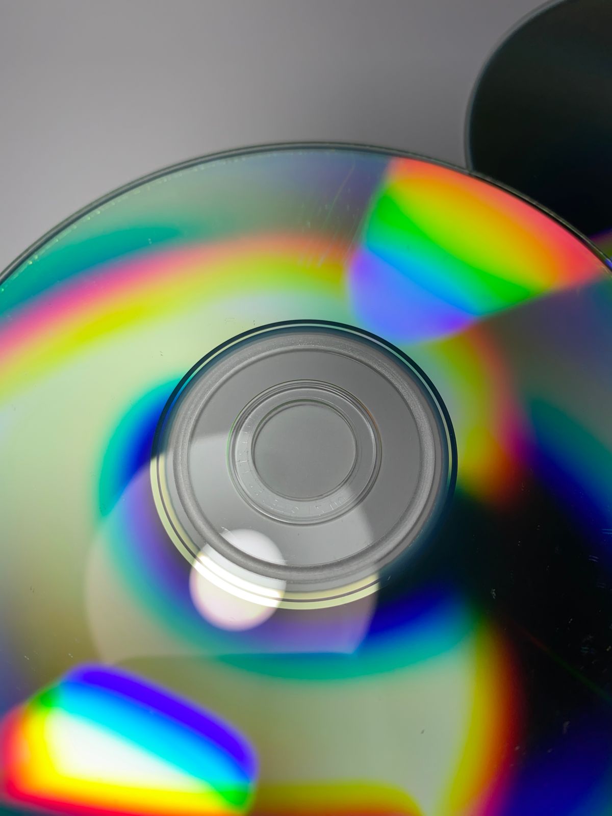 Close-up of a CD showcasing vibrant rainbow reflections on its glossy surface, a classic everyday example of a reflection diffraction grating