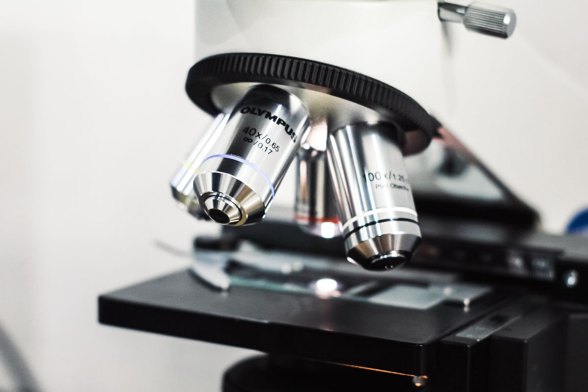Close-up of a laboratory microscope with optical lenses demonstrating how the critical angle of reflection affects oil immersion microscopy