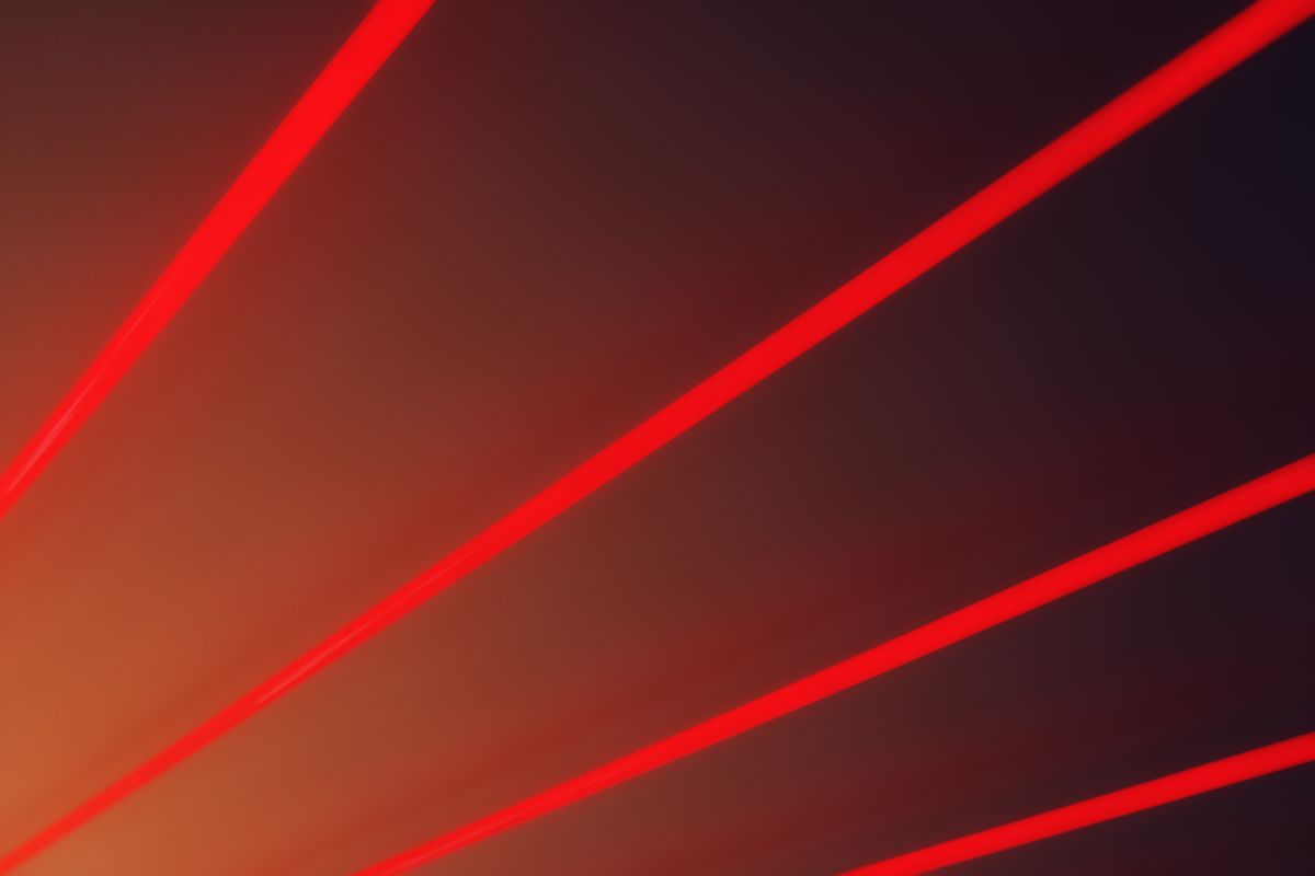 Abstract image with vibrant red laser beams on a dark gradient backdrop, illustrating the coherent diffraction pattern produced by a single slit