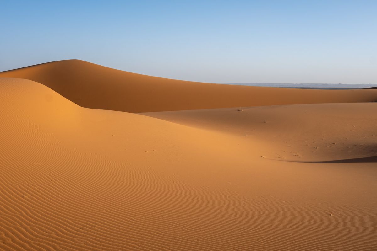 Open desert landscape with a clear horizon line showing where desert mirages typically appear as a shimmering reflection on the ground