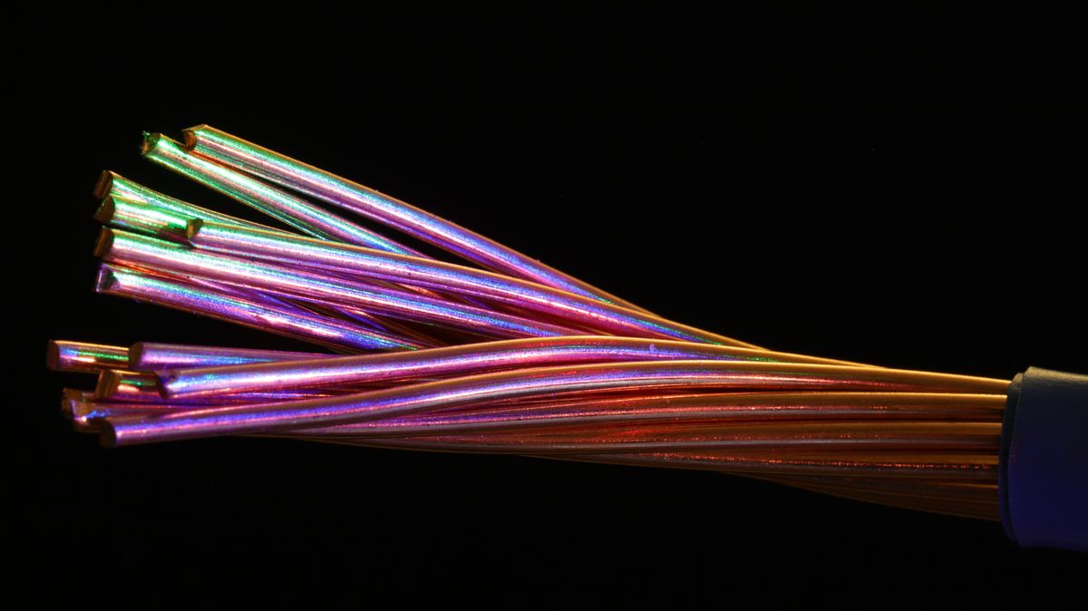 Vibrant multicolor fiber optic cables against a dark setting, showcasing the many strands inside a fiber optic cable