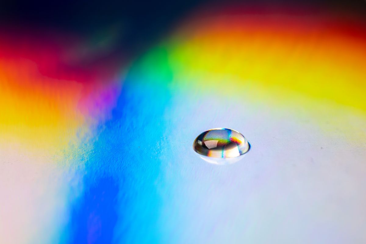 Water droplet showing prismatic rainbow hues from refraction of light in water