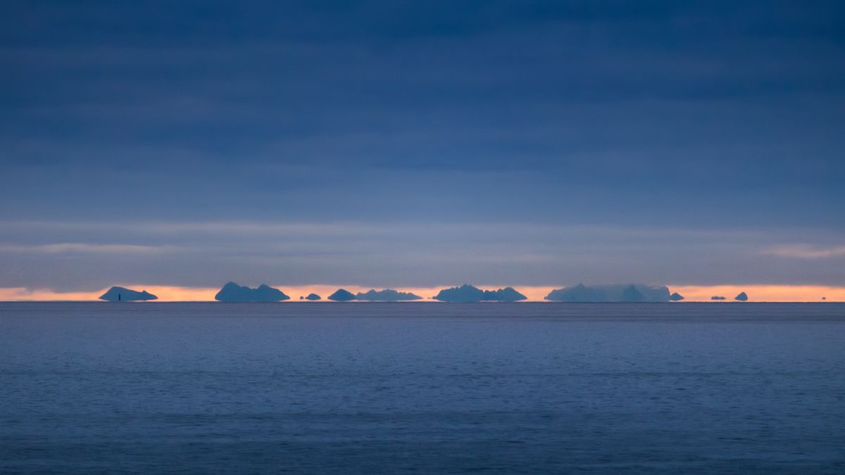 Dramatic sunrise over the sea and islands in Nordland, Norway, a coastal landscape similar to the Strait of Messina where Fata Morgana mirages have been observed for centuries