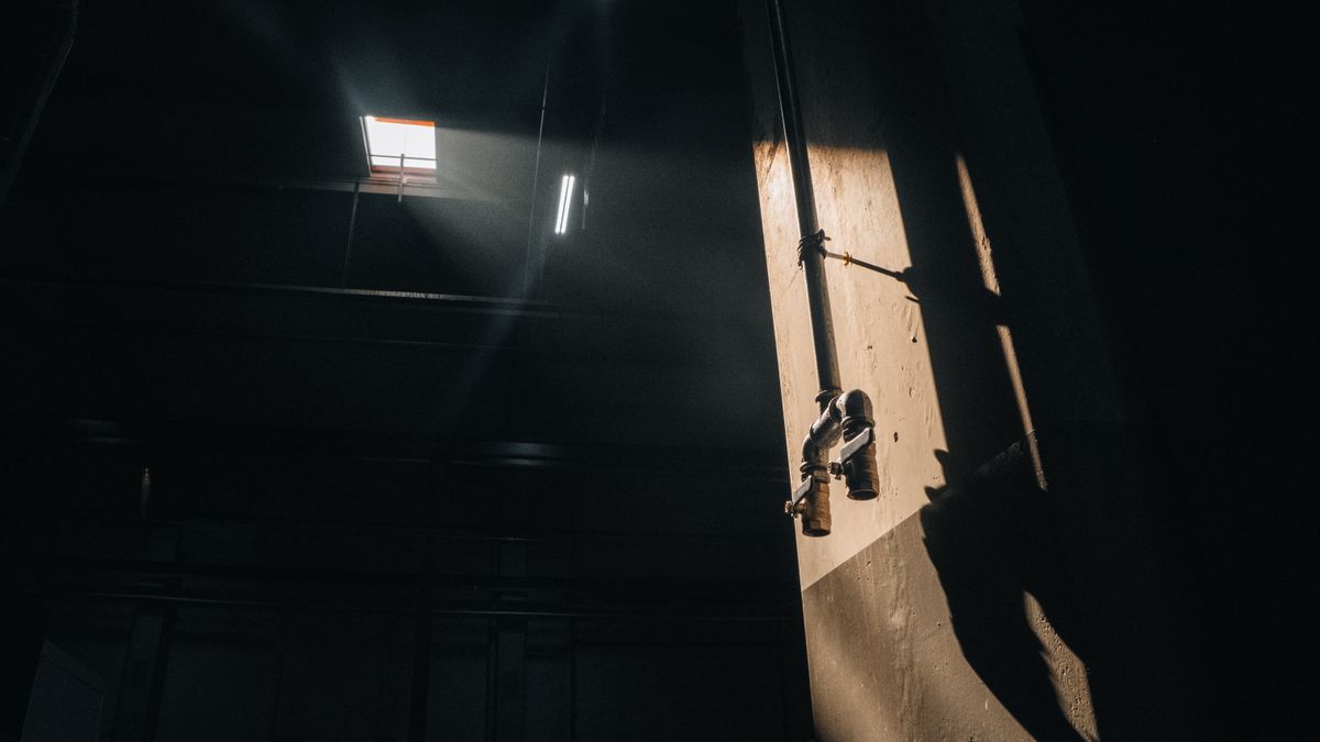 Dramatic lighting on industrial pipes casting shadows indoors for light piping application