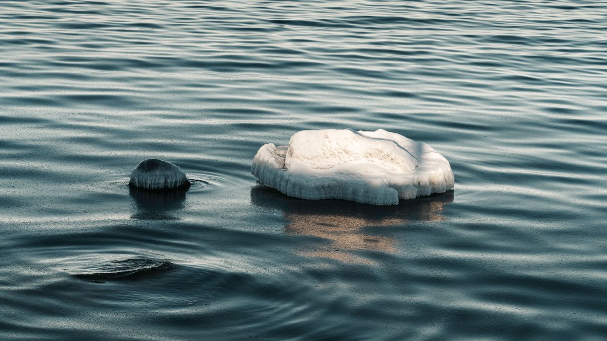 Ice chunks floating on calm ocean waters, representing the polar conditions where Fata Morgana mirages produce phantom islands and ghost ship sightings