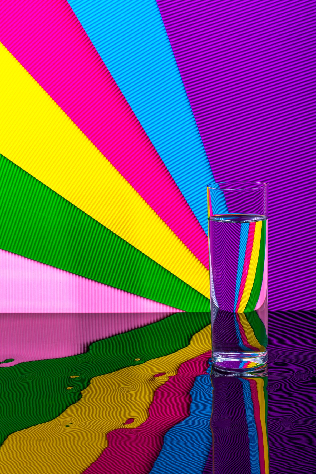 Colourful rainbow stripes reflected in a glass of water showing light dispersion through refraction
