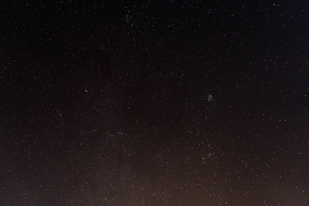 Why do stars twinkle: a starry night sky full of bright, shimmering stars above a dark landscape