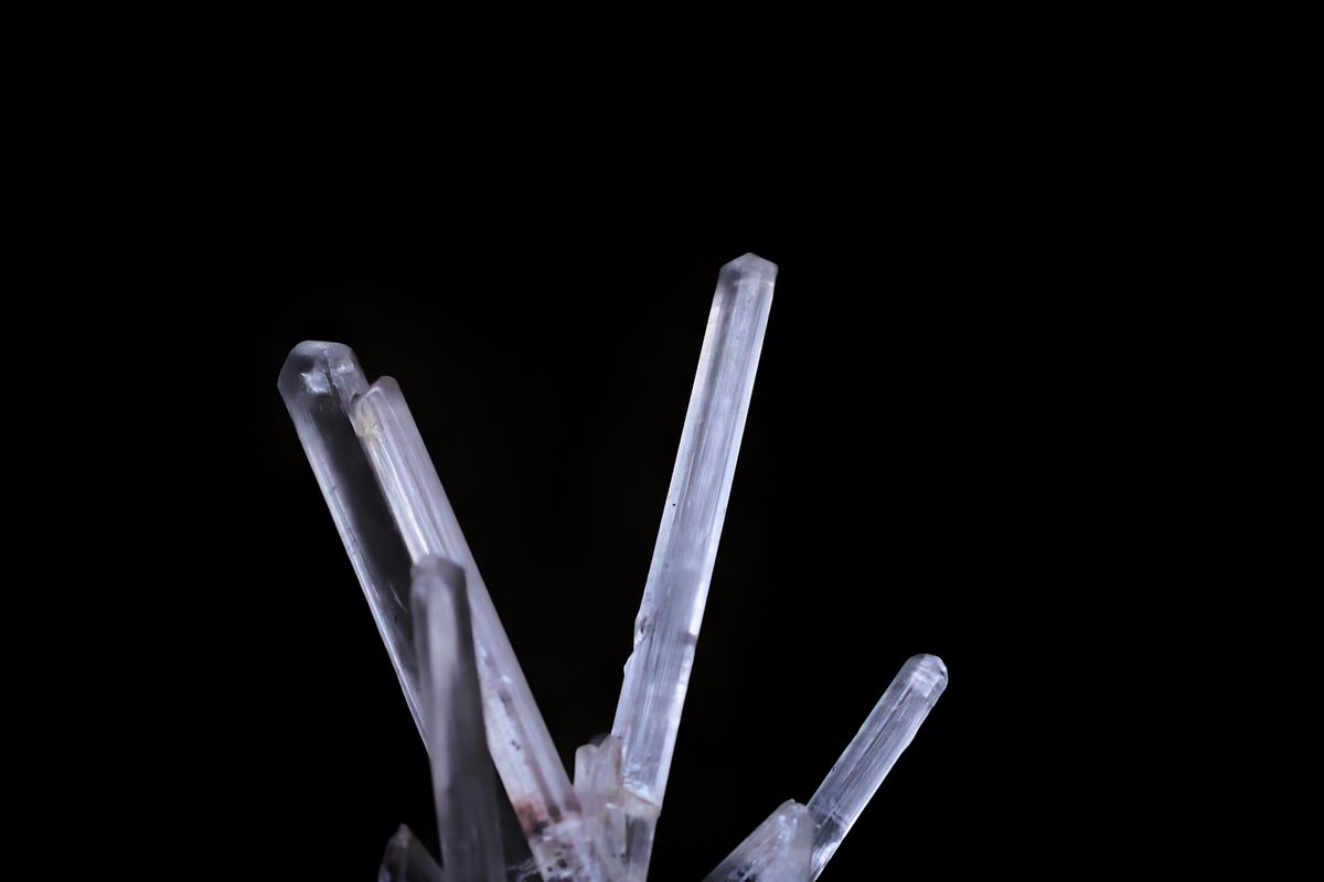 Macro shot of a clear quartz crystal formation, representing the crystalline gain medium used in solid-state lasers