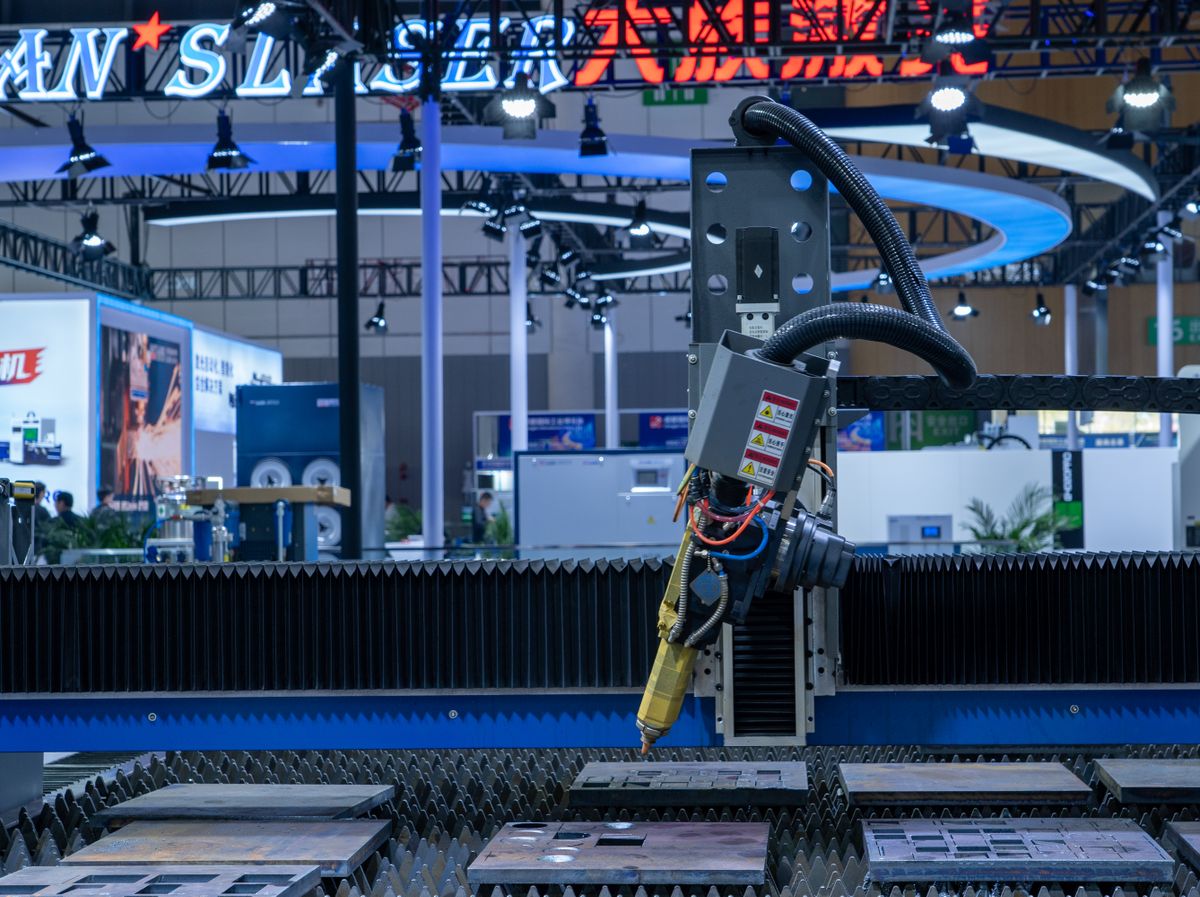Laser or lazer spelling: a close-up of a CNC laser machine operating at a high-tech industrial exhibition showing laser cutting technology