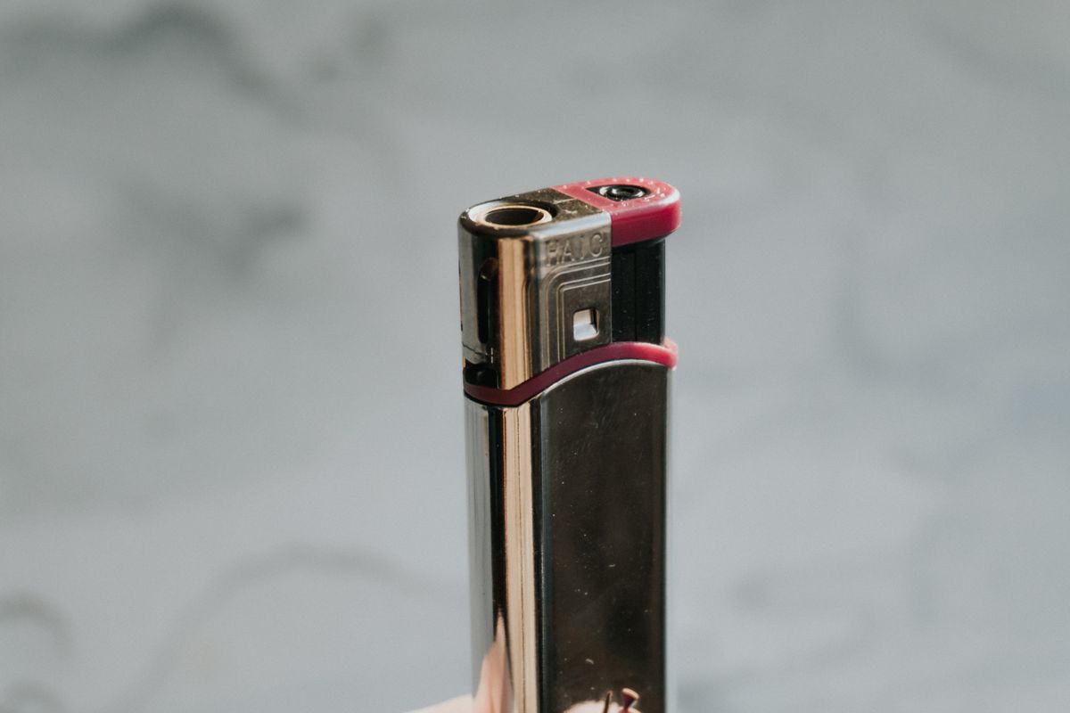 A metallic cigarette lighter, showing the parts of how a lighter works