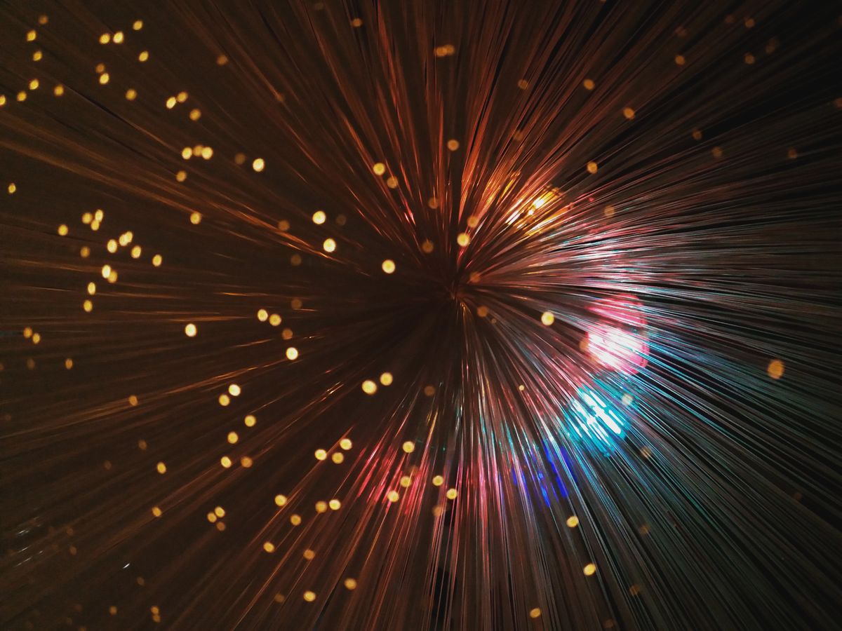 Abstract colorful fiber optic light strands against dark background showing decorative fiber optic lighting effects