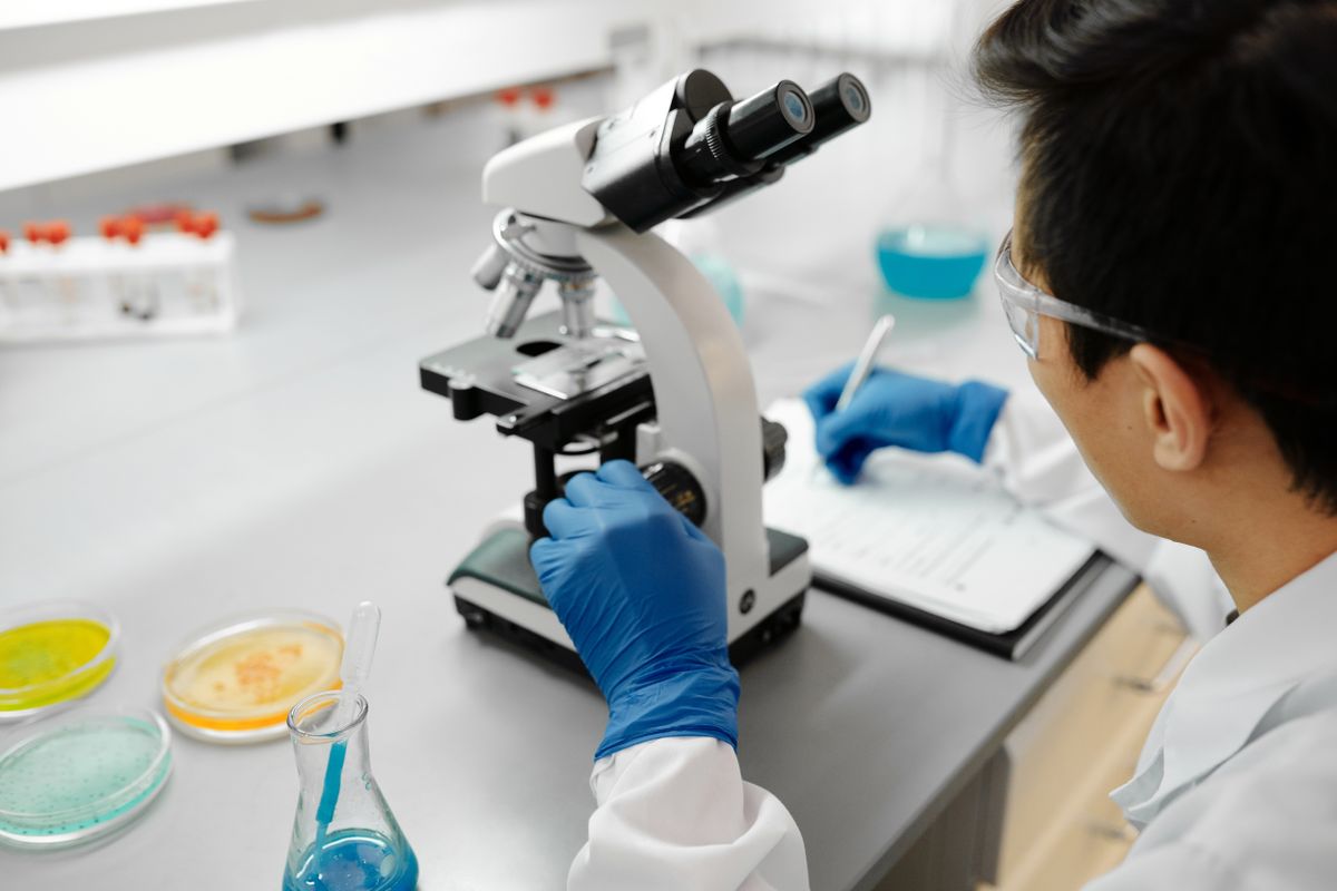 How does an electron microscope work: scientist using a microscope in a laboratory setting for scientific research