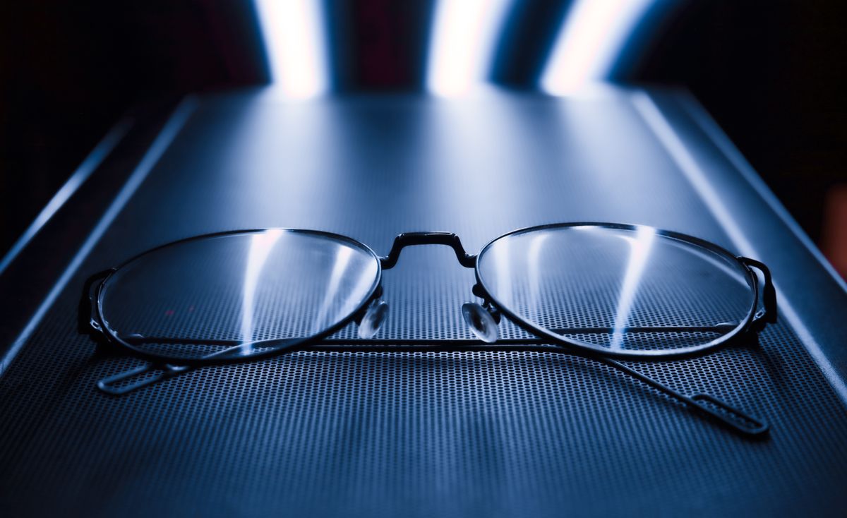Eyeglasses reflecting blue light, showing how blue light glasses filter the spectrum