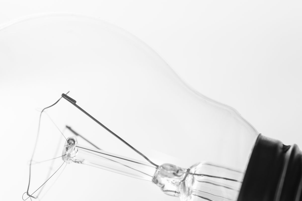 A clear glass light bulb showing the parts of a light bulb inside
