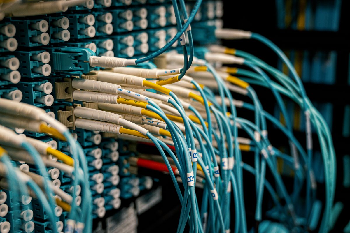 Fiber optic cable buying guide close-up: a fibre optical device with bright connectors and blue cables in a switch