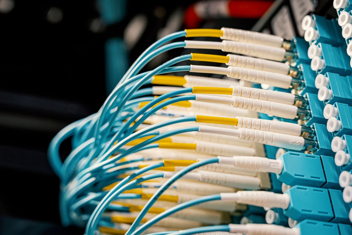 What does fiber optic cable look like: a fibre optical switch with connected cables in a modern server room showing a real installation