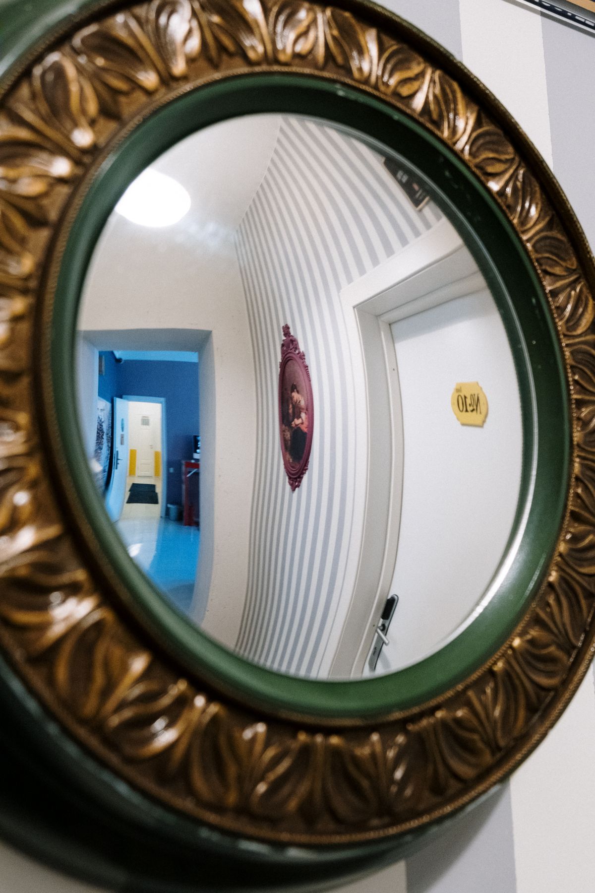 A decorative mirror reflecting a hallway with a convex effect, showing what happens when light hits a mirror of different shapes