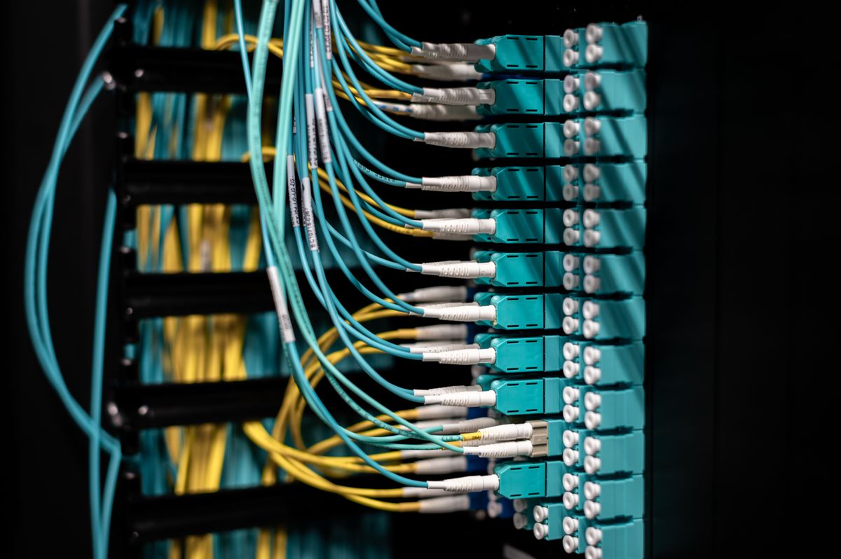 Fiber optic bandwidth in action: patch cables connected to a fibre optic switch in a data centre showing high-bandwidth network infrastructure