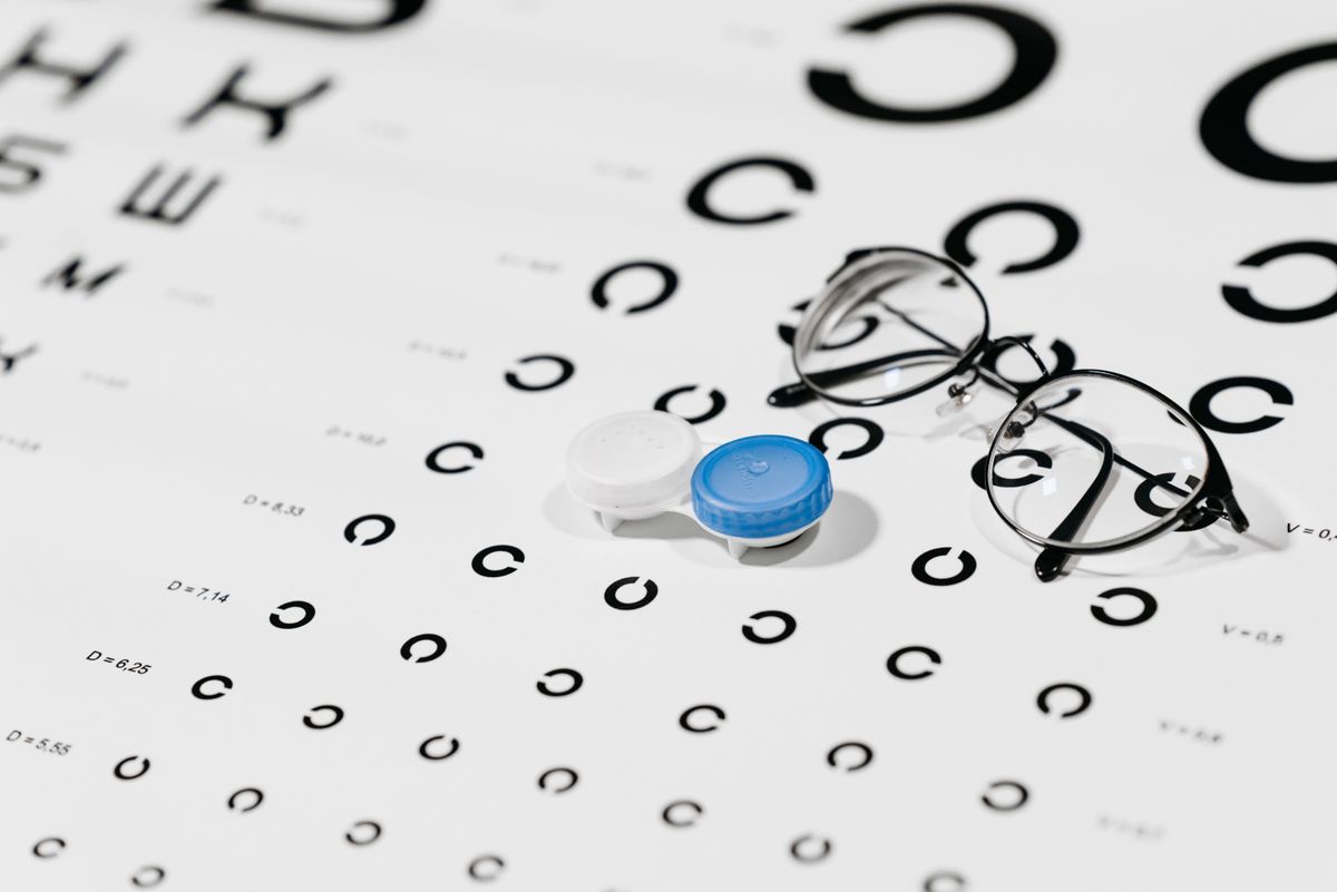 Eyeglasses resting on an eye test chart, showing convex lenses used to correct farsightedness