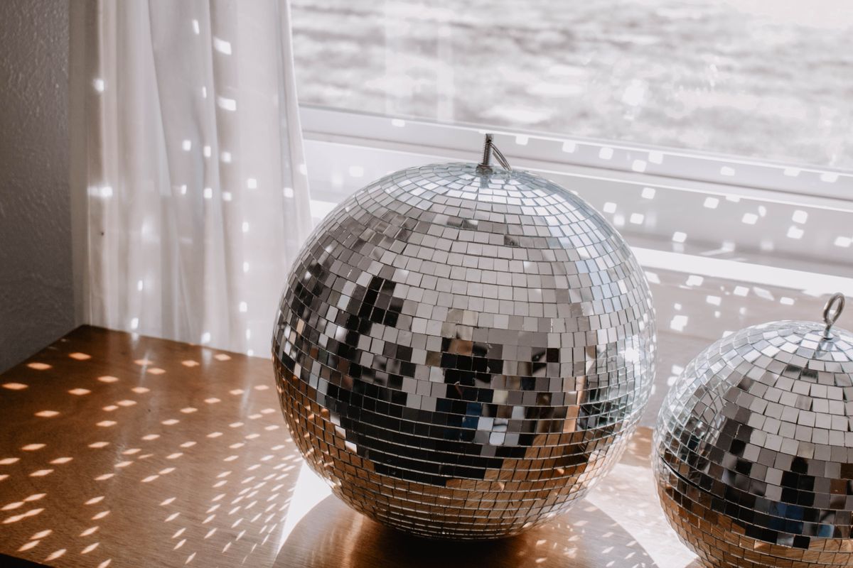 Close-up of shiny disco balls reflecting light patterns, an everyday reflection of light examples with multiple specular reflections