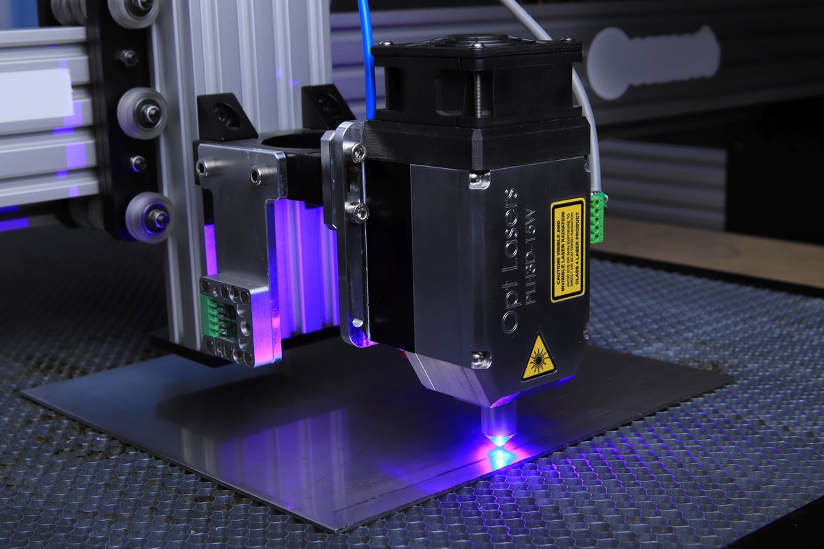 Close-up of a laser engraving machine operating on metal, showing a solid-state laser application in manufacturing
