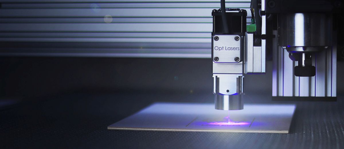 Close-up of a laser engraving machine in operation, showing a practical application of laser light in manufacturing