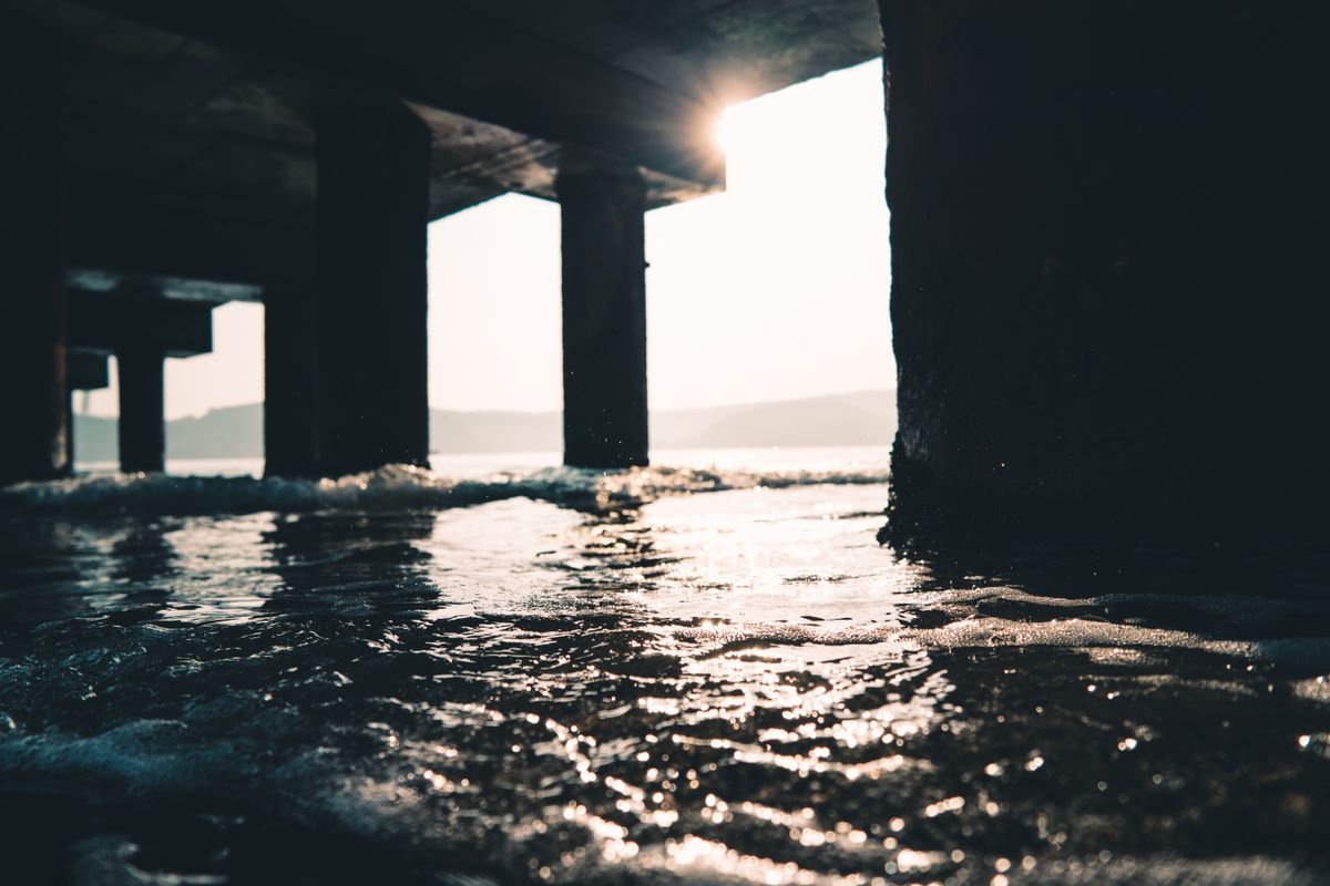 Unpolarized sunlight streaming through a pier before any surface partially polarises it