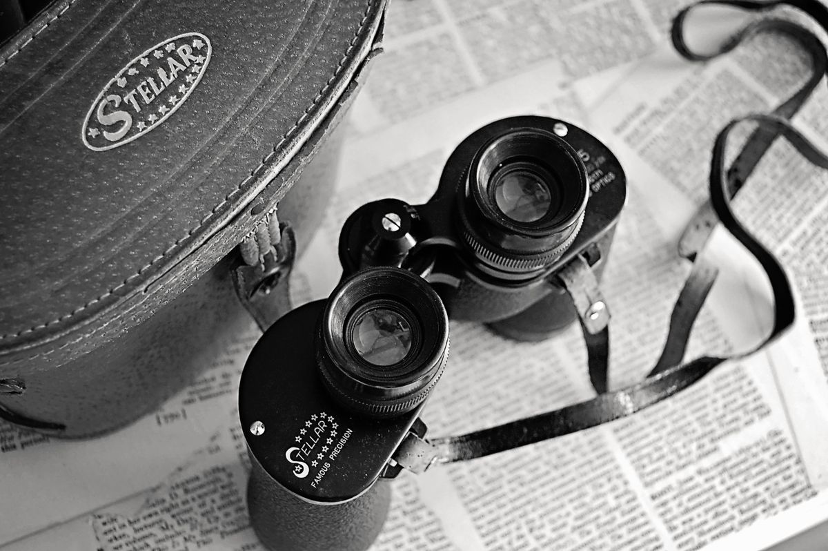 Classic optical instruments: a pair of vintage binoculars resting on an open leather case
