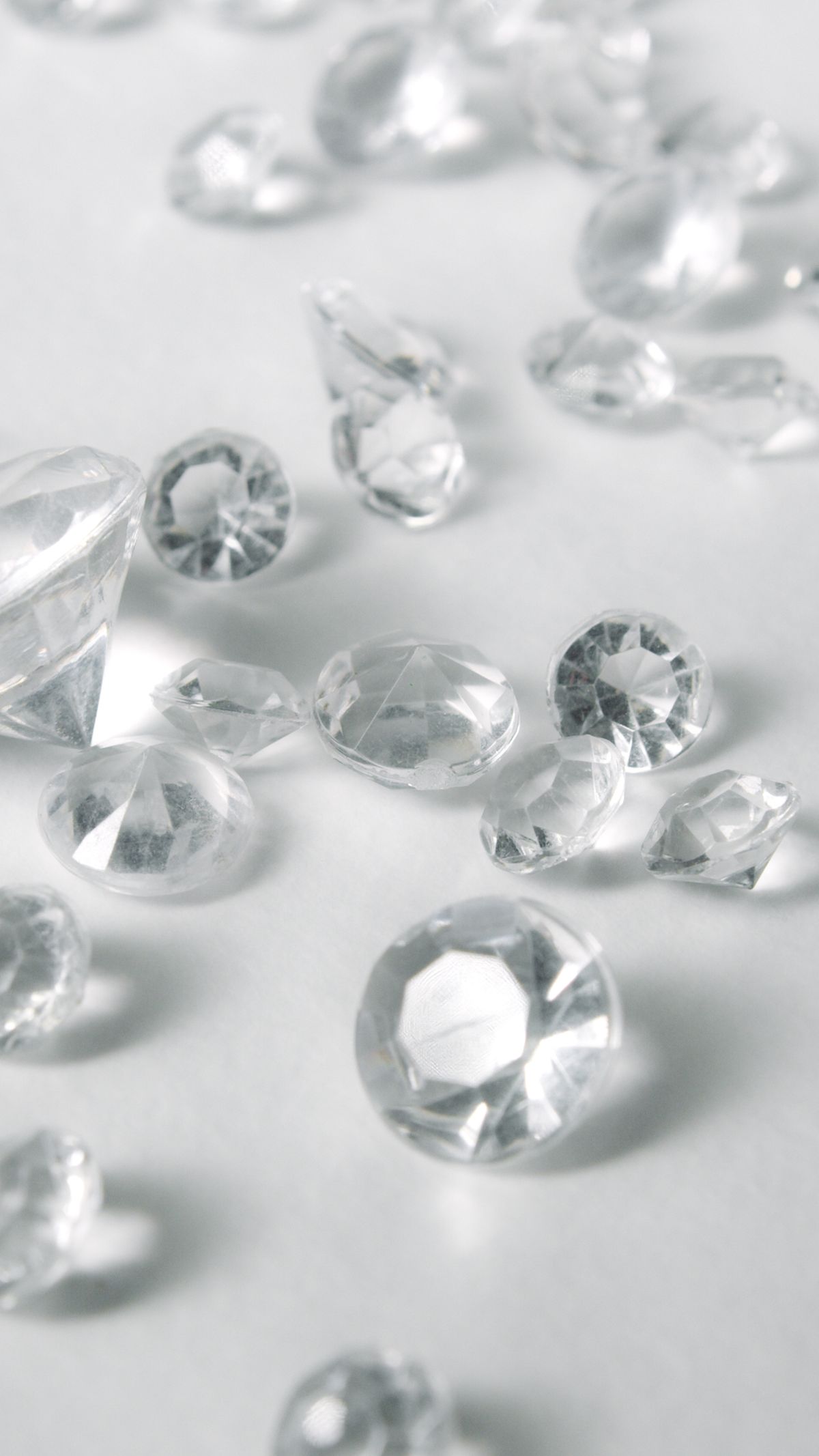 Clear crystal stones on white surface demonstrating how materials with different refractive indices have different critical angles