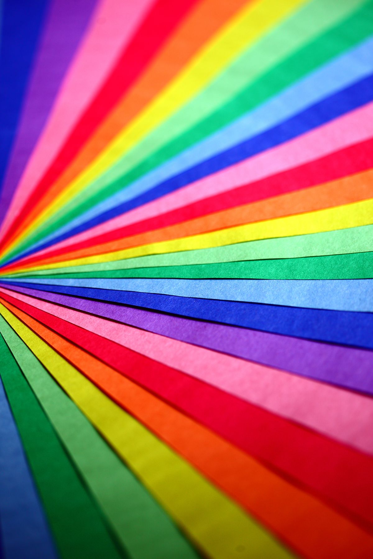 Colorful abstract overlapping rainbow papers showing the colors of the rainbow in order from red to violet in macro detail