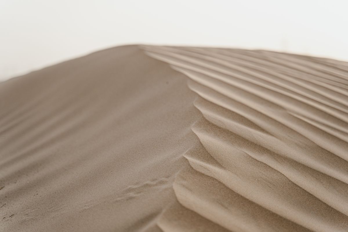 Desert mirages form over sand dunes with a hazy horizon, the classic conditions for this optical illusion