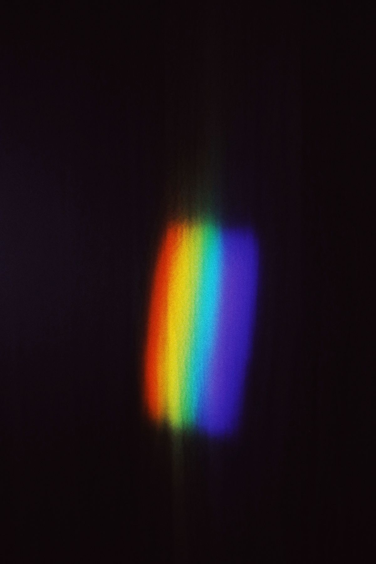 Vibrant rainbow light spectrum created by a prism demonstrating refraction and how Snell's law leads to the critical angle formula