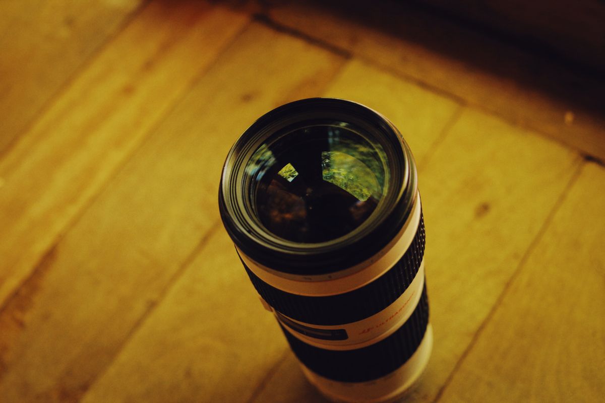 Close-up of a professional camera lens showing multiple converging lens elements used to focus light onto a sensor